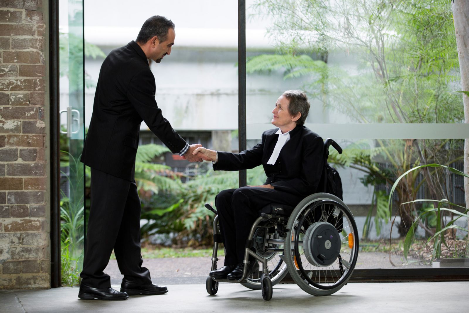Person in a wheelchair shaking hands with someone