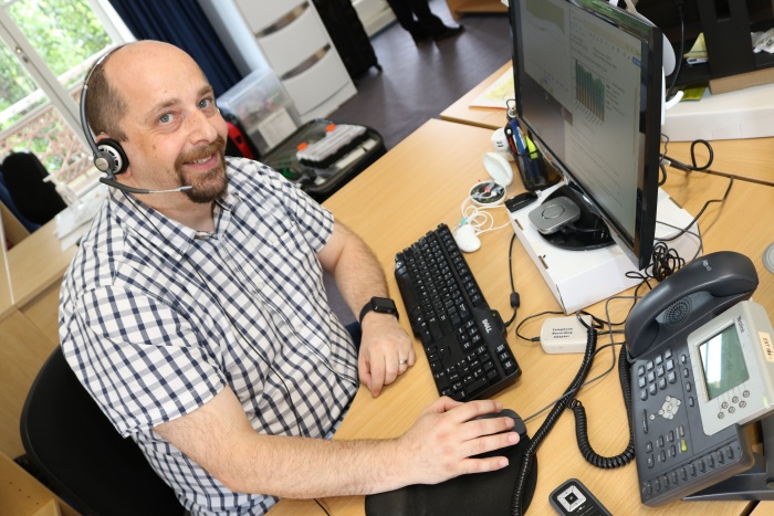 Photo: Daniel Pistritto at his workstation with assistive hearing devices funded by the Employment Assistance Fund (Source: Blamey Saunders hears)