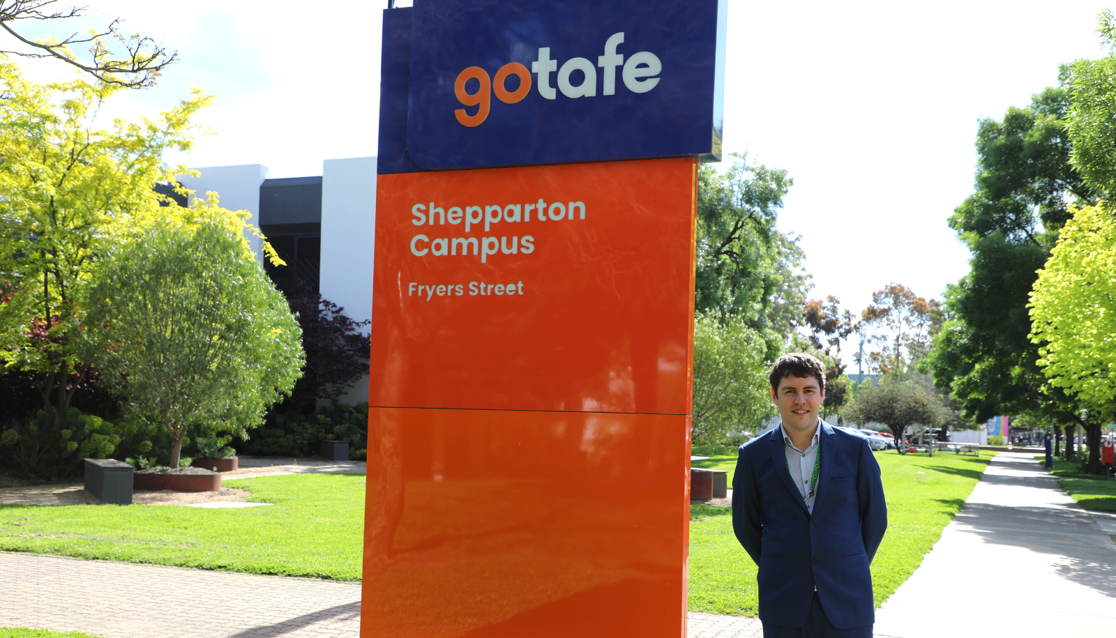 Daniel Gardner, Coordinator for Diversity and Inclusion at GOTAFE, standing next to the institution’s Shepparton Campus Fryers Street sign