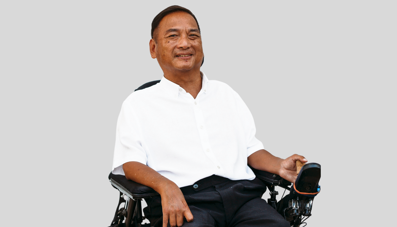 Jude Lee sitting in a wheelchair and smiling at the camera.